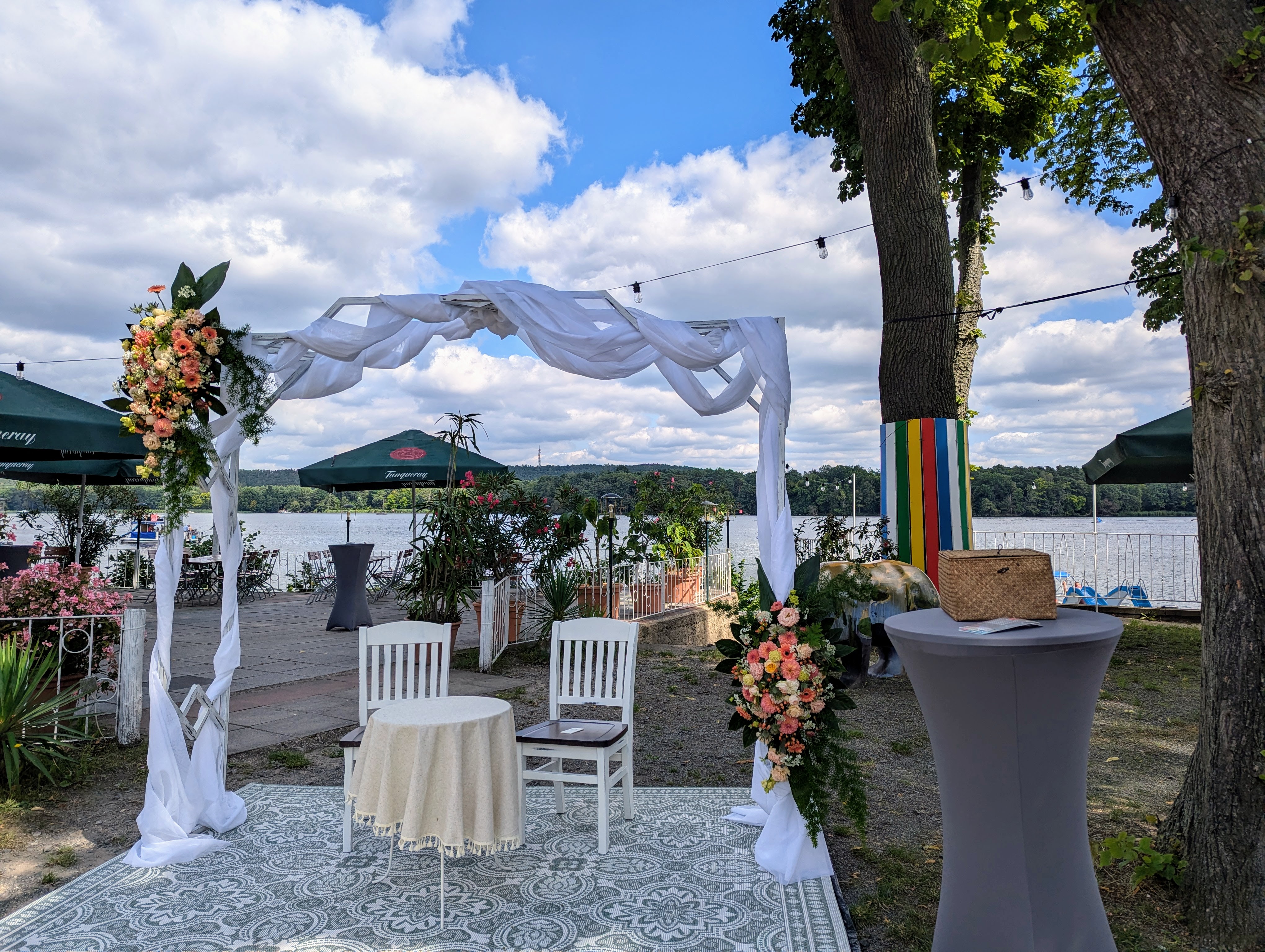 Traubogen auf der Terrasse mit Stehtischen und weitem Blick ueber den See.