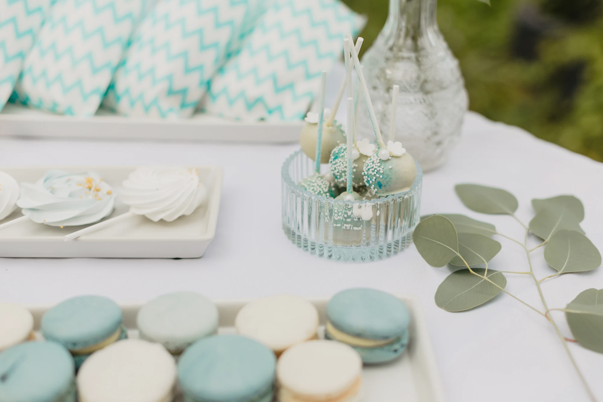 Macarons und kleine Suessigkeiten auf einer hellen Candy-Bar am See.