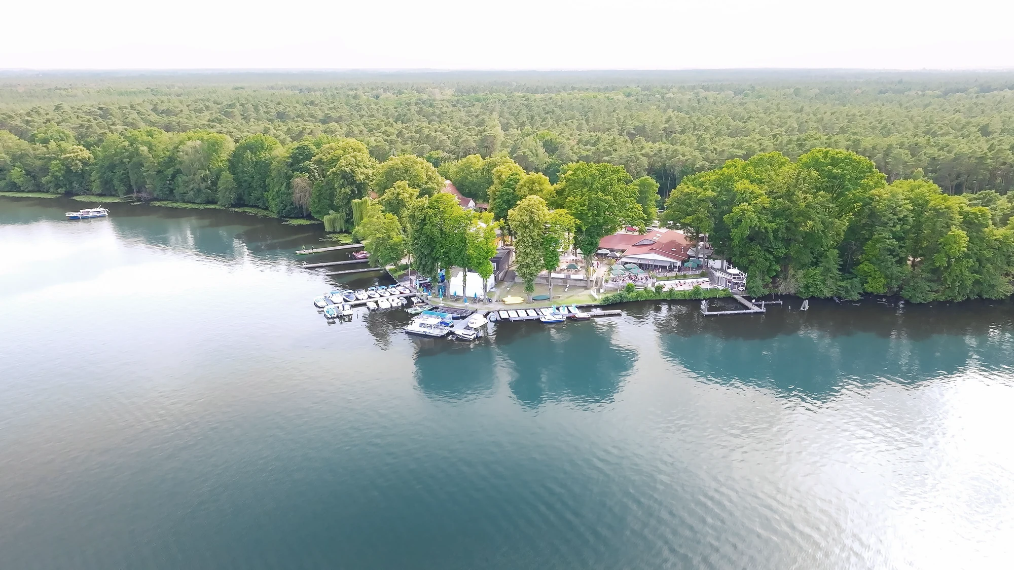Drohnenblick auf das Richtershorn am gruenen Seeufer in Berlin-Treptow-Köpenick.