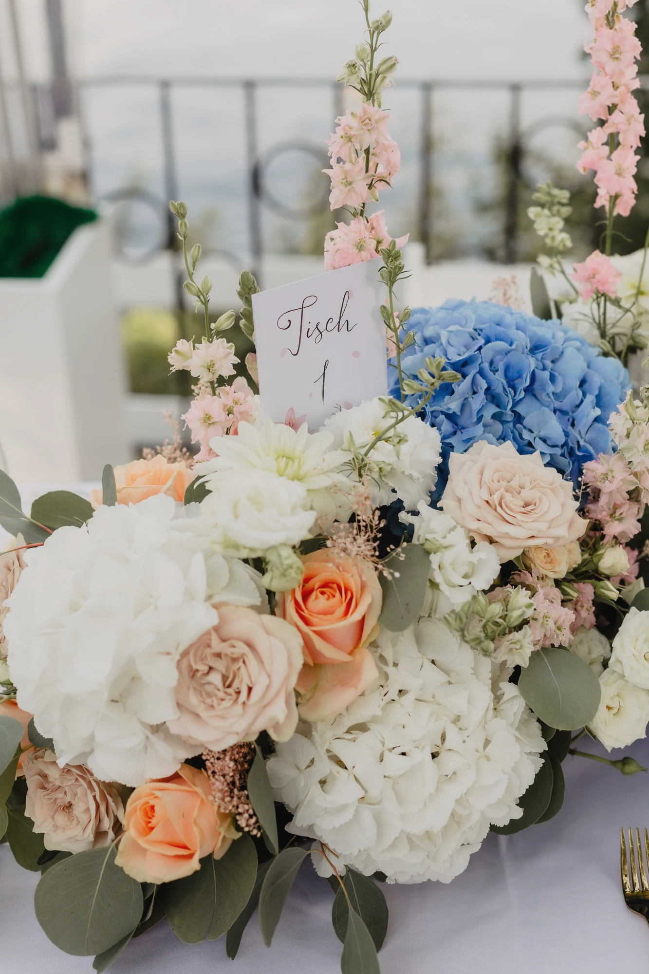 Nahaufnahme eines farbigen Blumengestecks mit blauen Hortensien und Rosen.