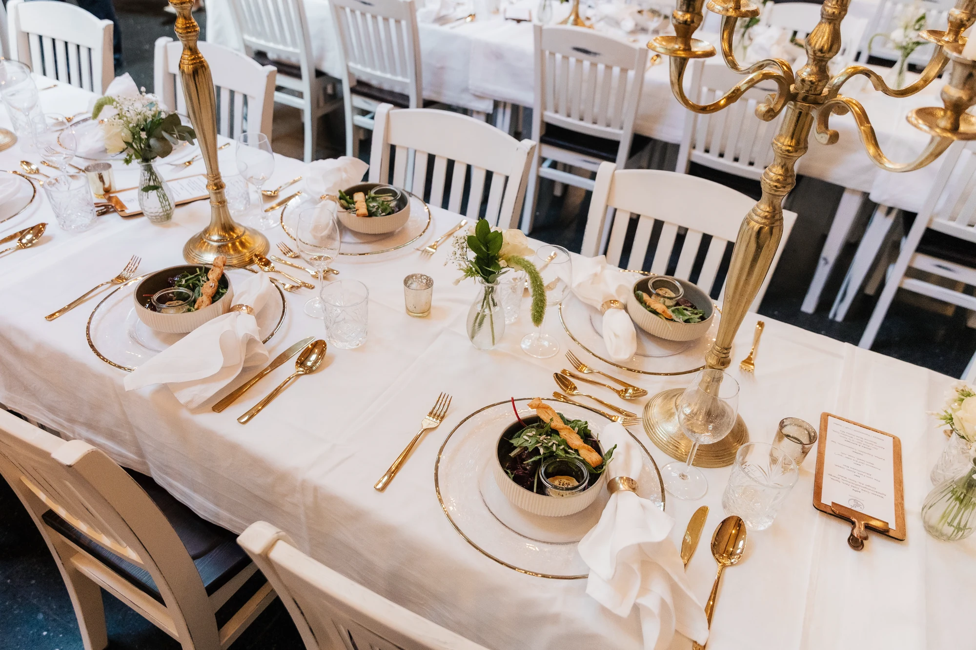 Festliche Hochzeitstafel mit Kerzen und Goldbesteck im Großen Saal.