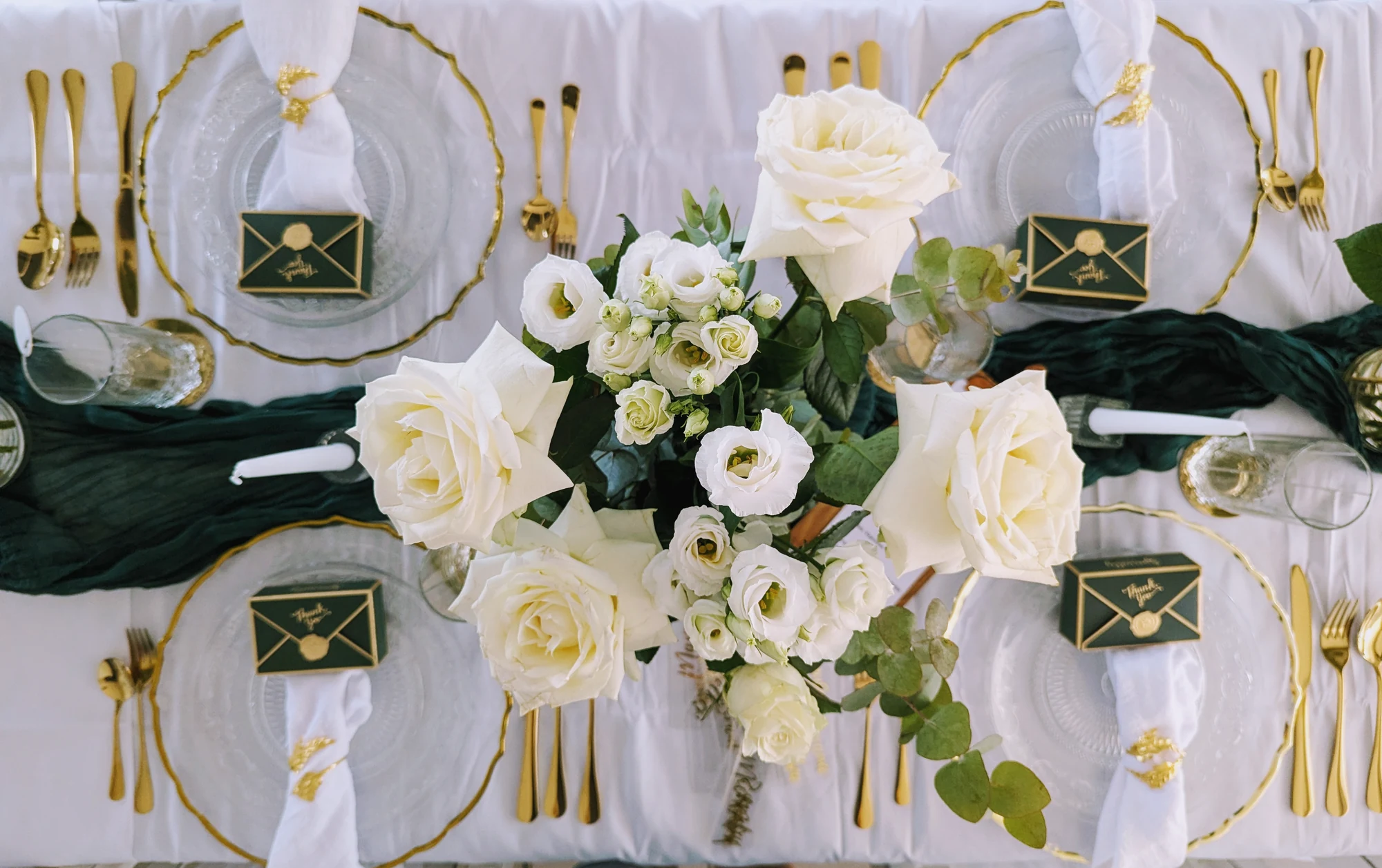 Blumengesteck mit weissen und blauen Blueten auf einer festlichen Tafel.