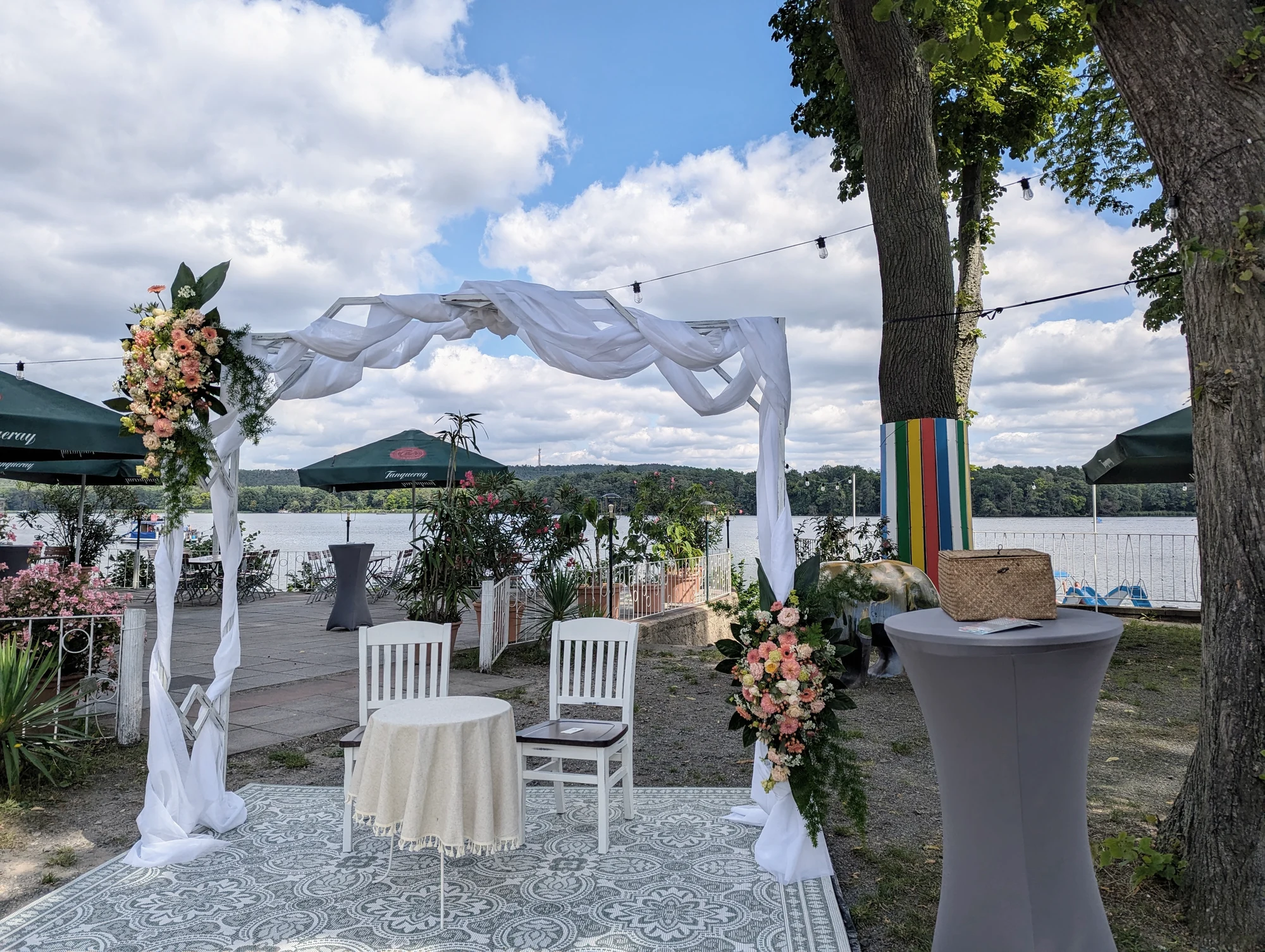Traubogen auf der Terrasse mit Stehtischen und weitem Blick ueber den See.