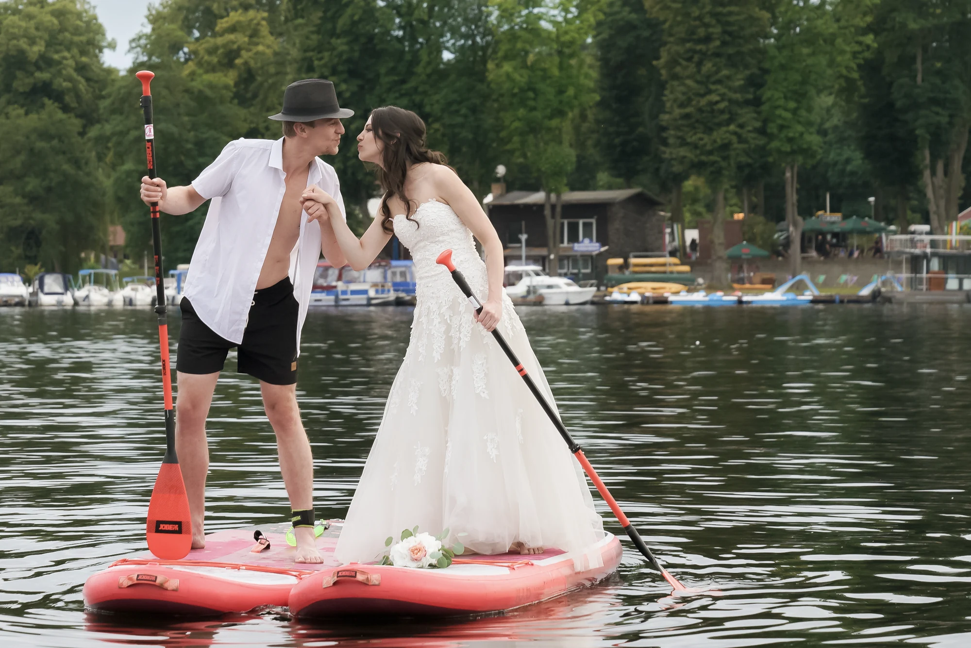 Brautpaar kuesst sich auf einem SUP-Board vor dem Ufer des Richtershorns.