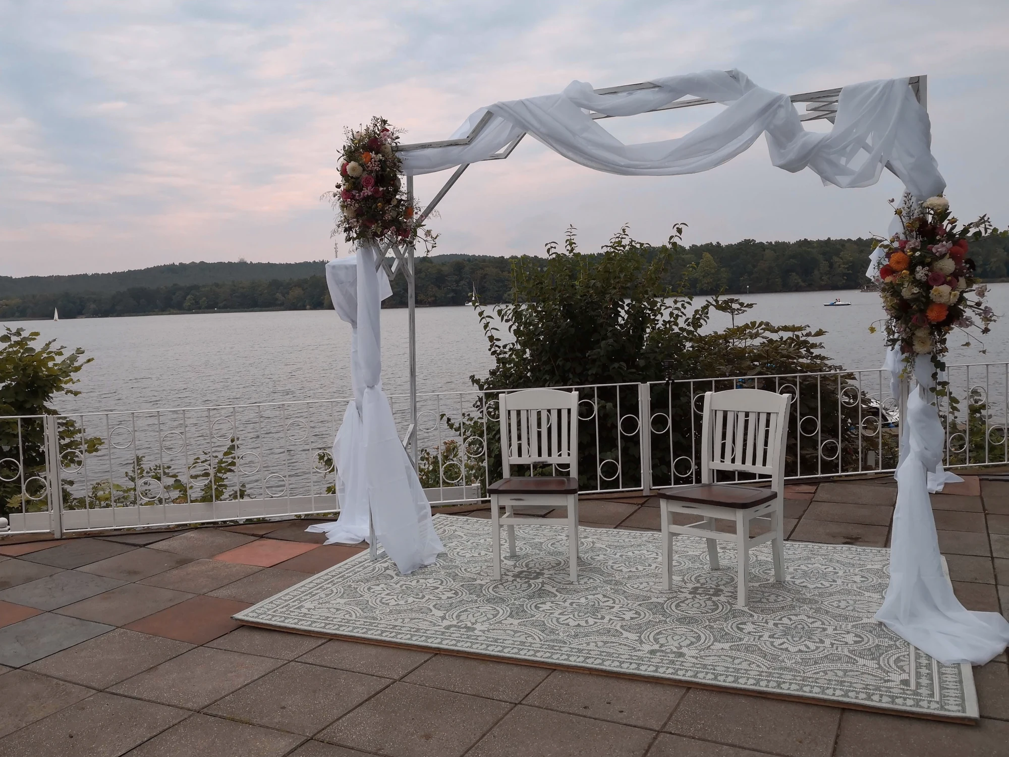 Weiss geschmueckter Traubogen auf der Terrasse mit direktem Blick auf den See.